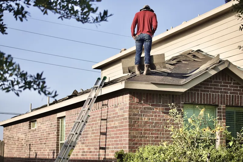 Professional roofer working on a residential roof in West Acton
